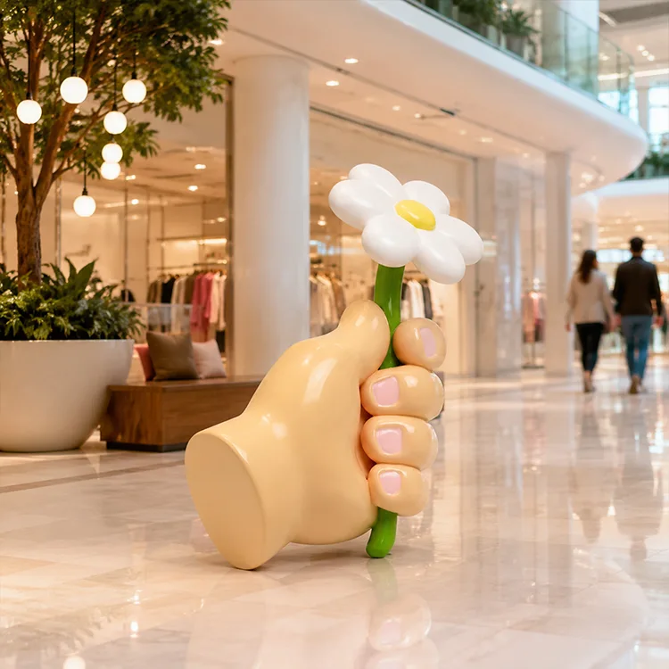 Hand hält Blumenskulptur